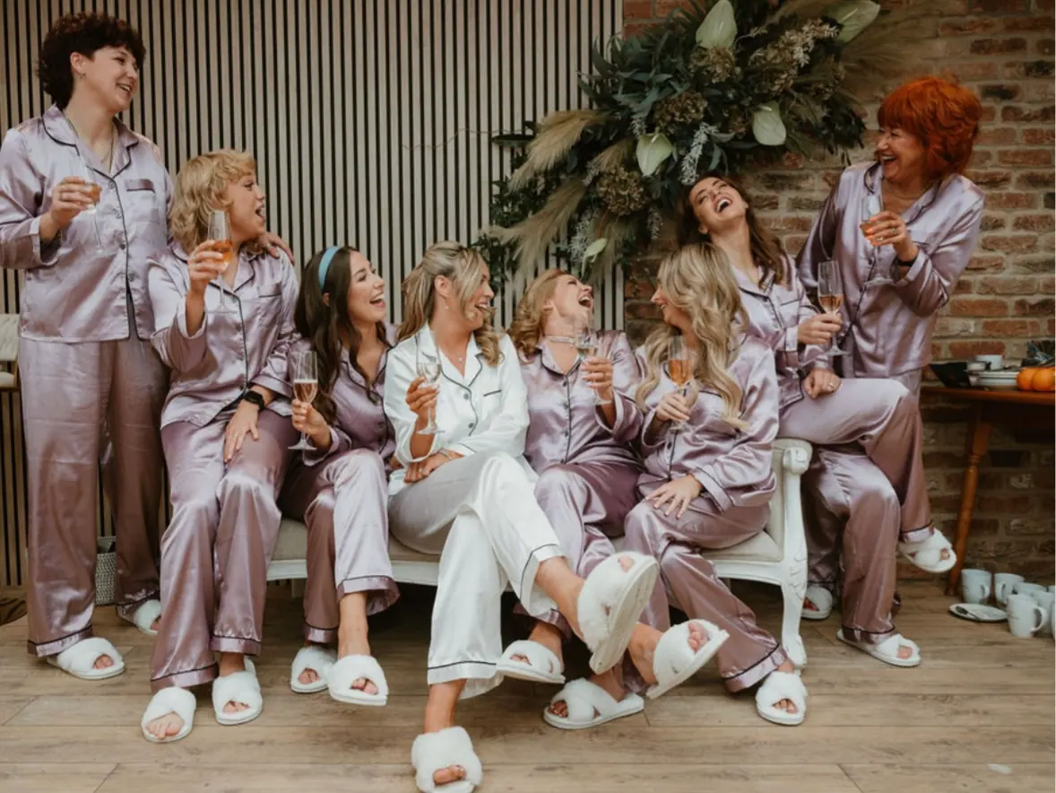 Hannah getting ready with women in silver and lilac satin robes