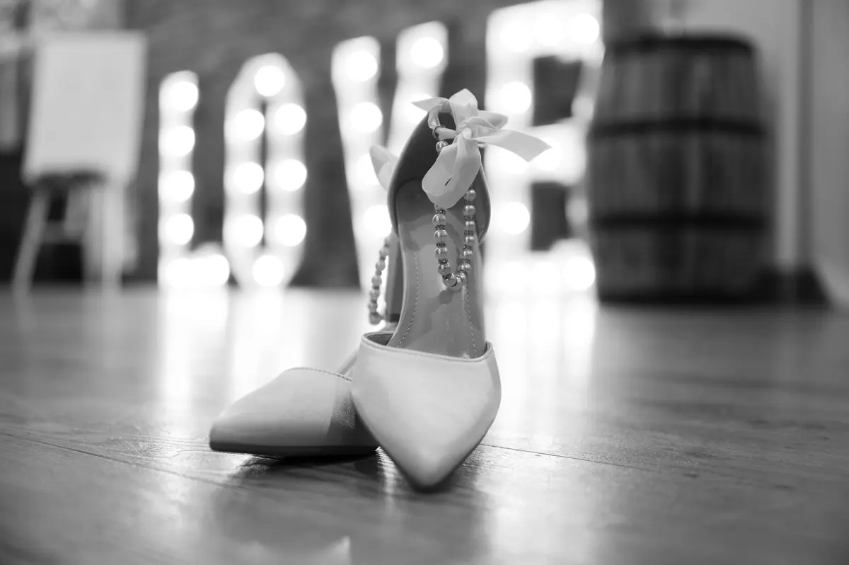 White pointed shoes with jewelled straps standing on the Hall floor