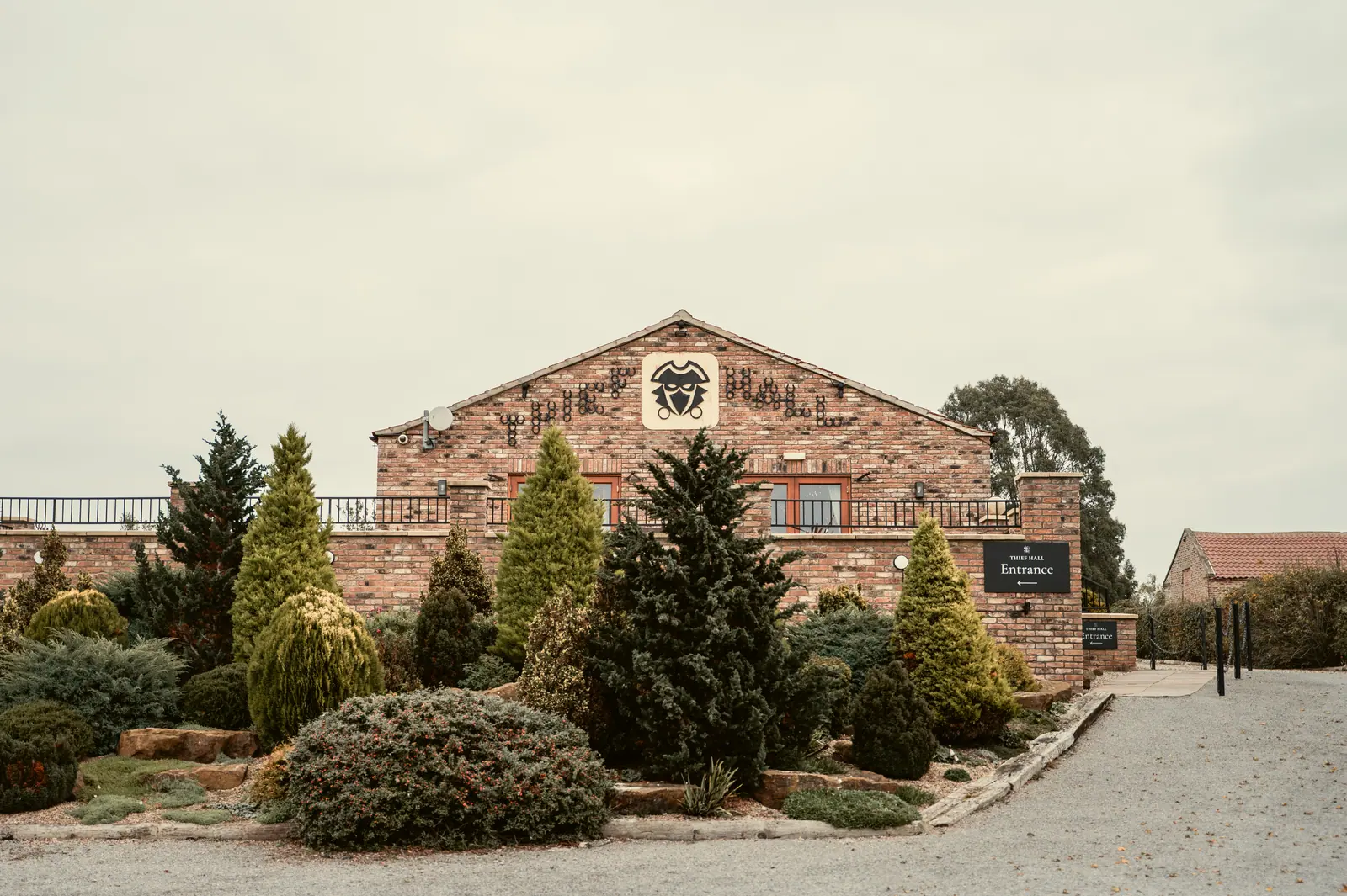 Stone Thief Hall entrance and courtyard beneath a pale autumn sky